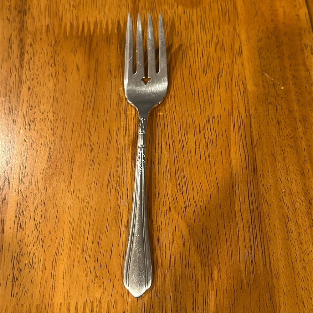 Oneida Tudor plate silver salad fork. Neck is rounded and has a slit edge.